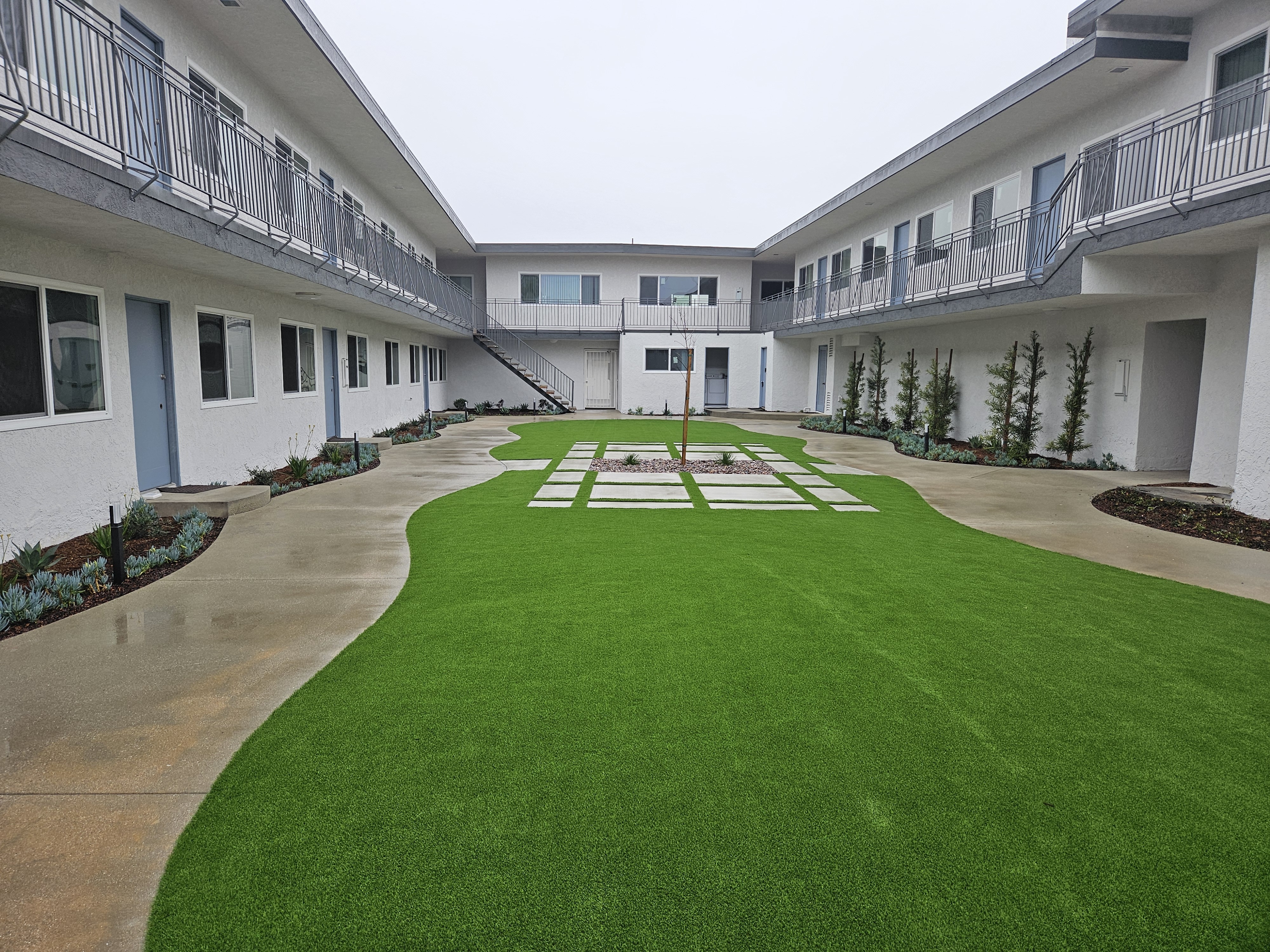 the courtyard of an apartment building with green grass