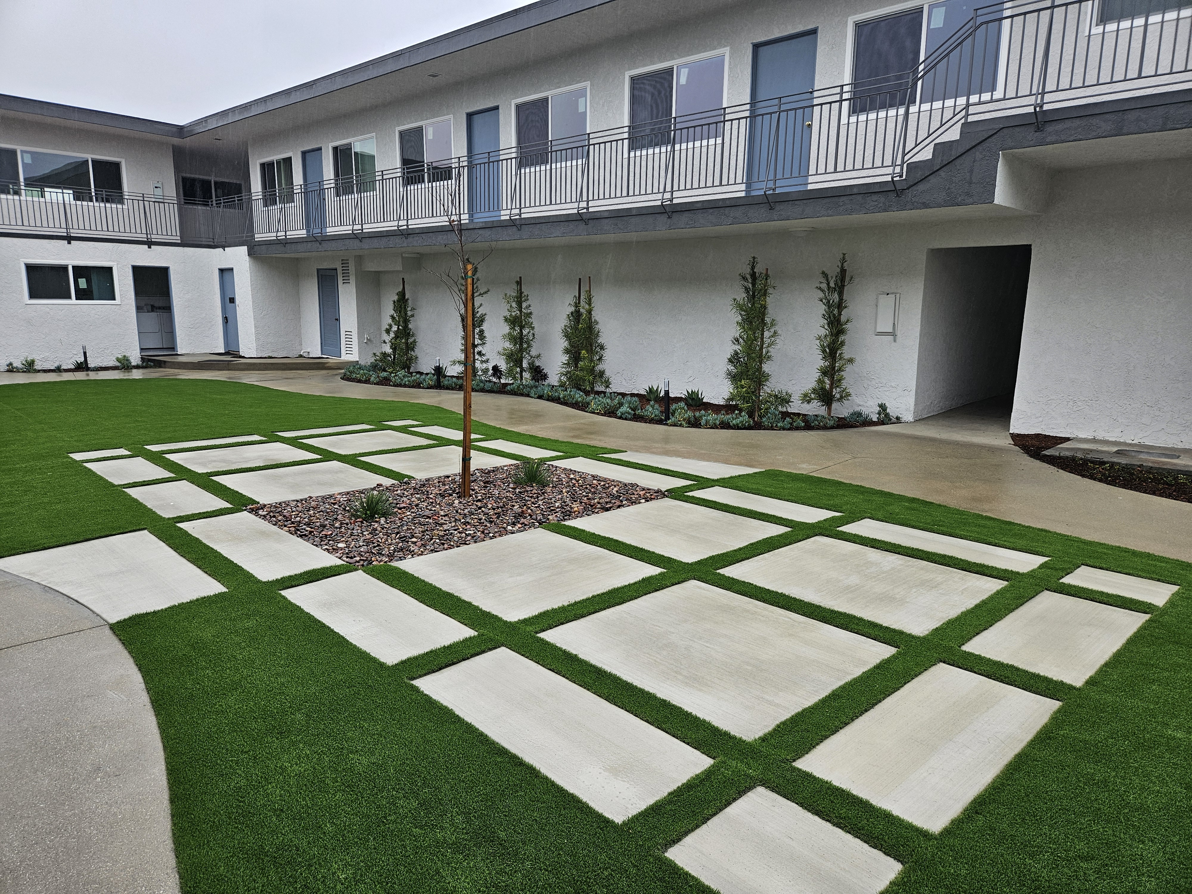 the courtyard of an apartment building with green grass
