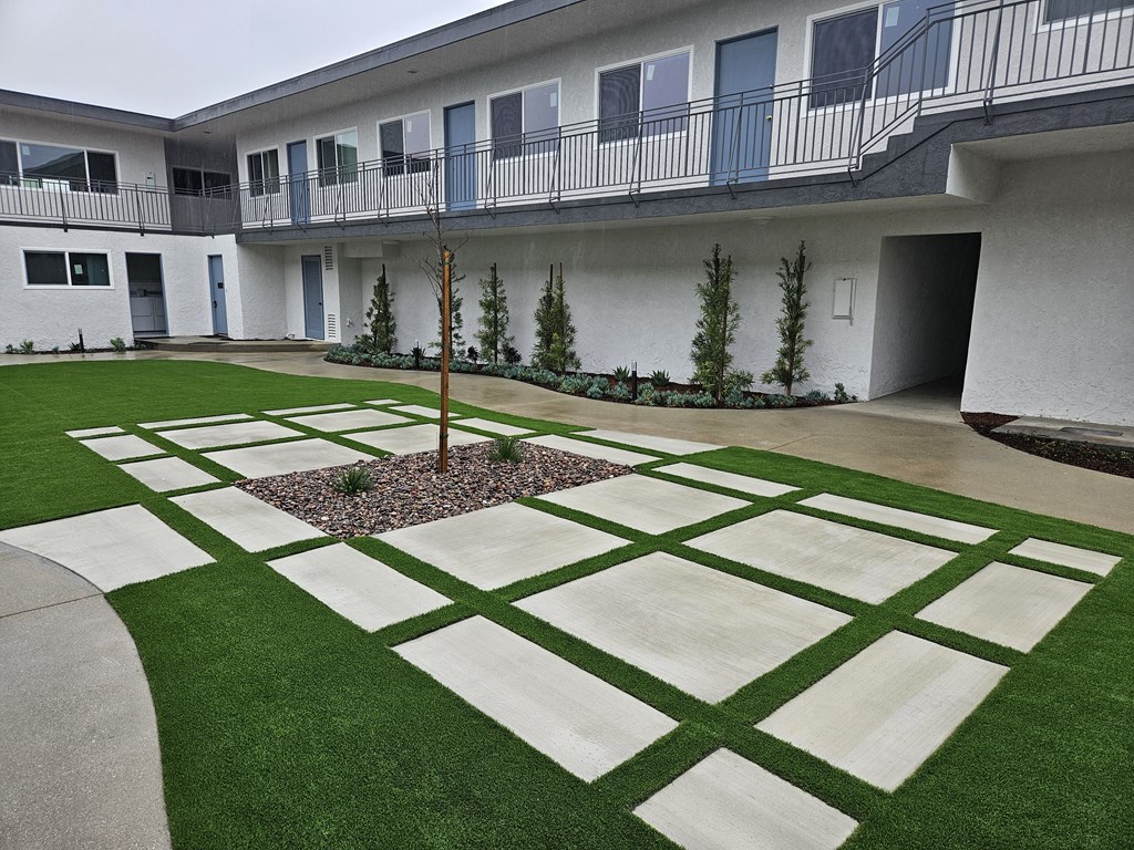 the courtyard of an apartment building with green grass