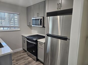 A kitchen at Charle Square with stainless steel appliances and white cabinets