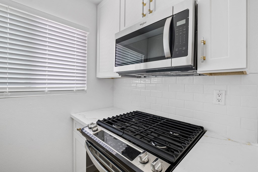 a kitchen with a stove and a microwave above it at Arlington Square Apartment , California