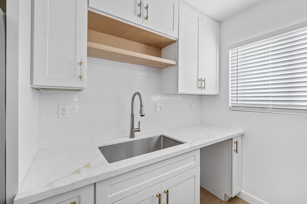 a white kitchen with a sink and white cabinets at Arlington Square Apartment , Torrance, 90501