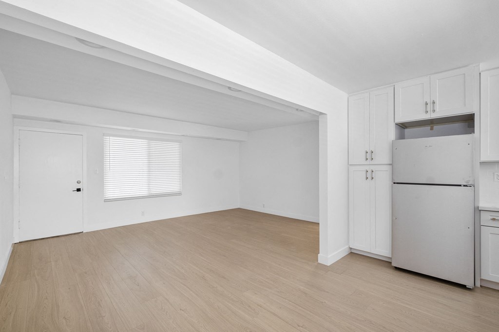 the living room of an apartment with white cabinets and a refrigerator the living room of an apartment with white cabinets and a refrigerator at Arlington Square Apartment , Torrance