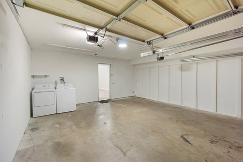 an empty garage with white walls and a washer and dryer
