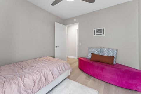 A bedroom with a pink bed and a pink bench at Tamarack Sands Apartment Homes, Carlsbad, 92008
