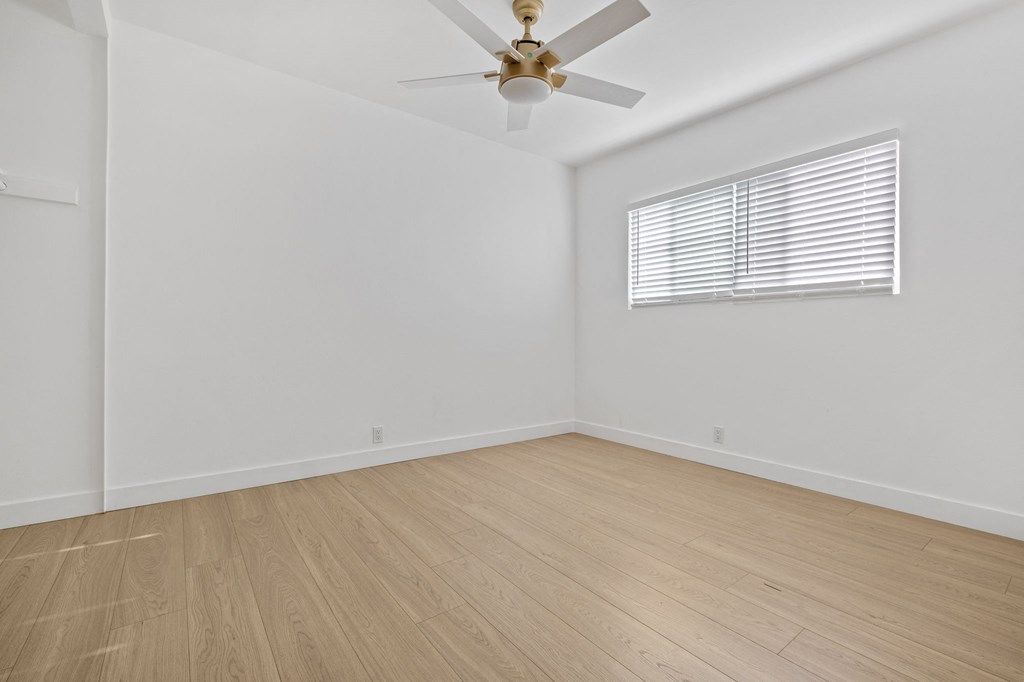 a living room with white walls and wood floors and a ceiling fan at Arlington Square Apartment , Torrance, CA