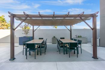 A patio with a table and chairs under a pergola.at The Reserve La Mirada, California, 90638