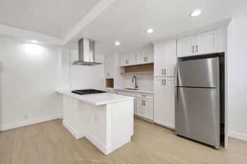 A kitchen with a white island and stainless steel appliances.