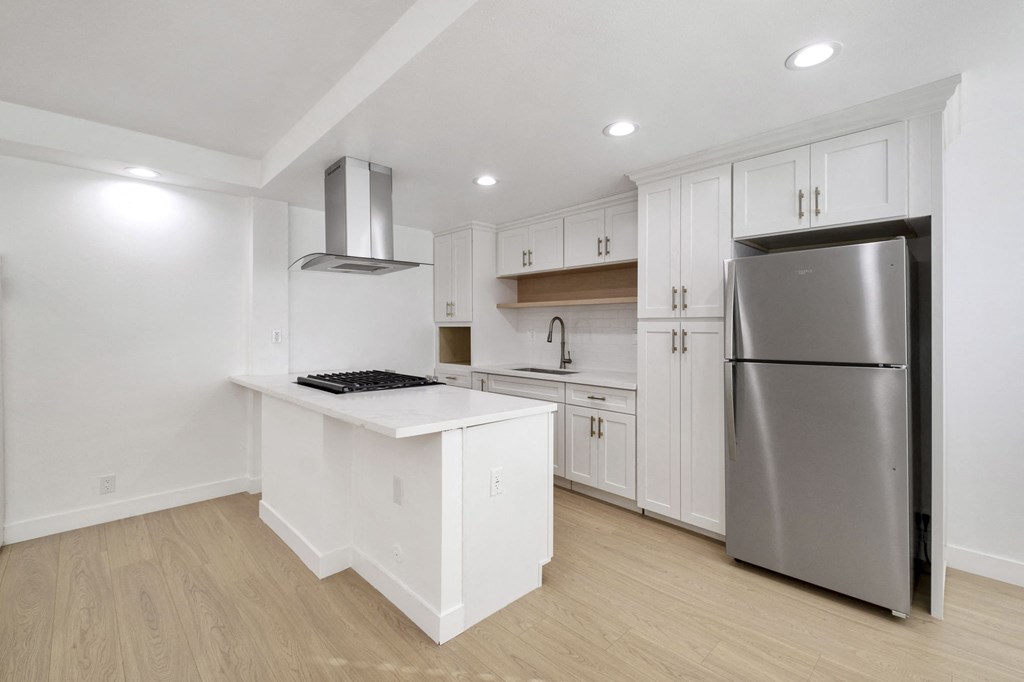 A kitchen with a white island and stainless steel appliances at Arlington Square Apartment , Torrance, California