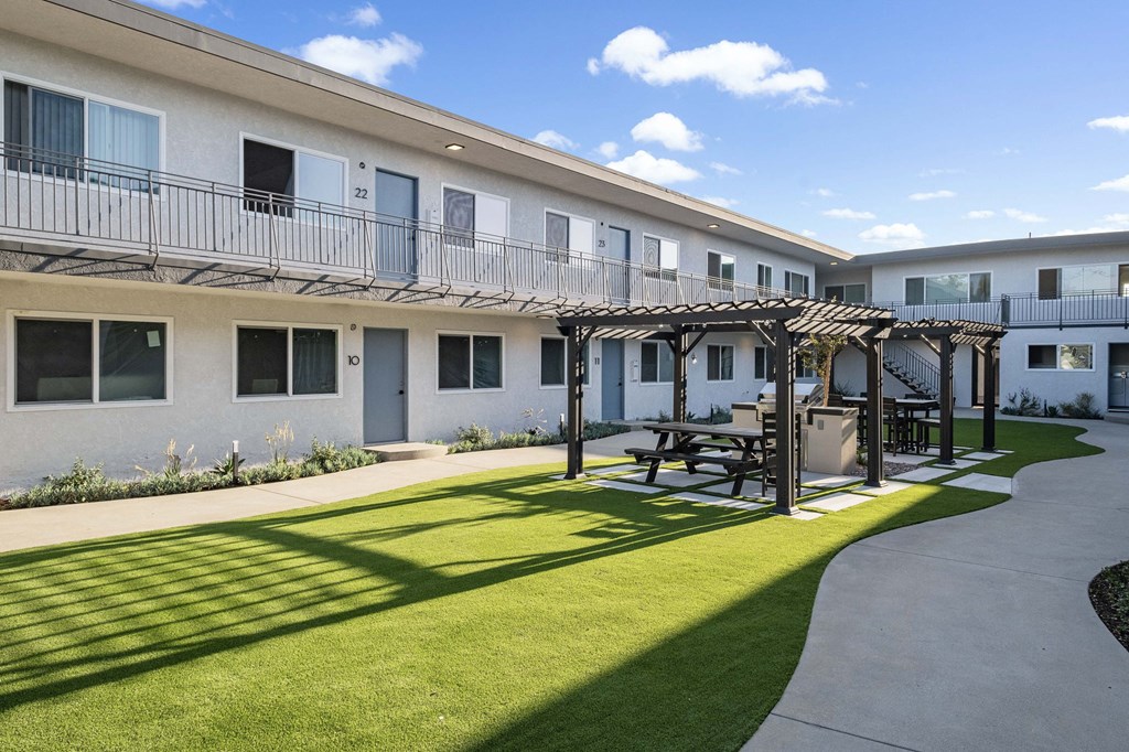 a patio with a table and chairs in front of a building at Arlington Square Apartment , Torrance, CA