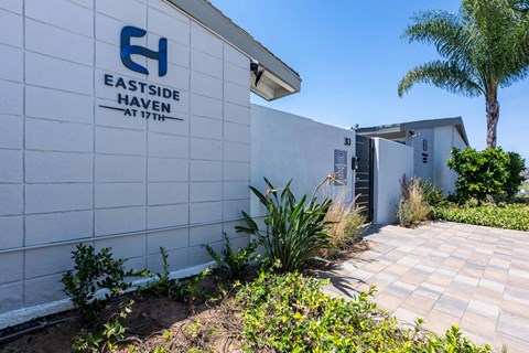 A white building with a blue logo that says Eastside Haven at 17th.