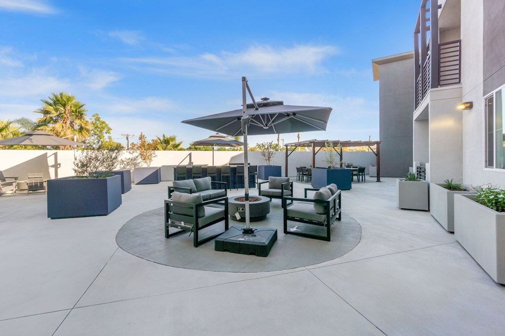 A patio with a table and chairs under an umbrella.at The Reserve La Mirada, La Mirada, 90638