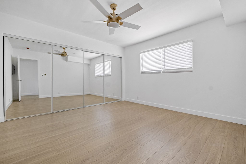 a large room with white walls and a ceiling fan at Arlington Square Apartment , Torrance, California