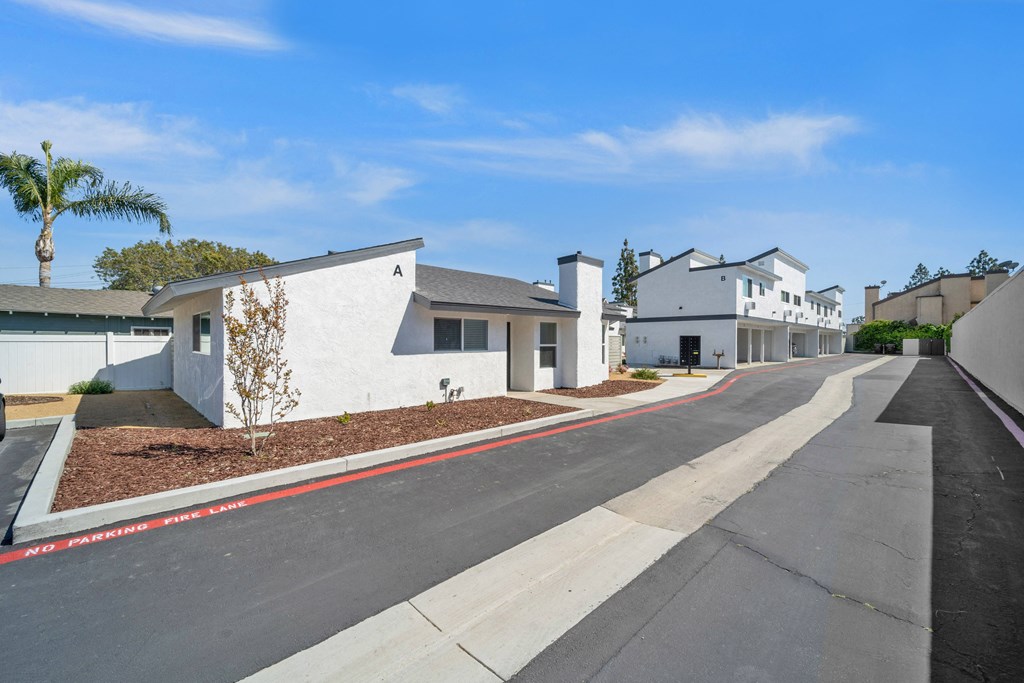 a street with white houses and a clear blue sky