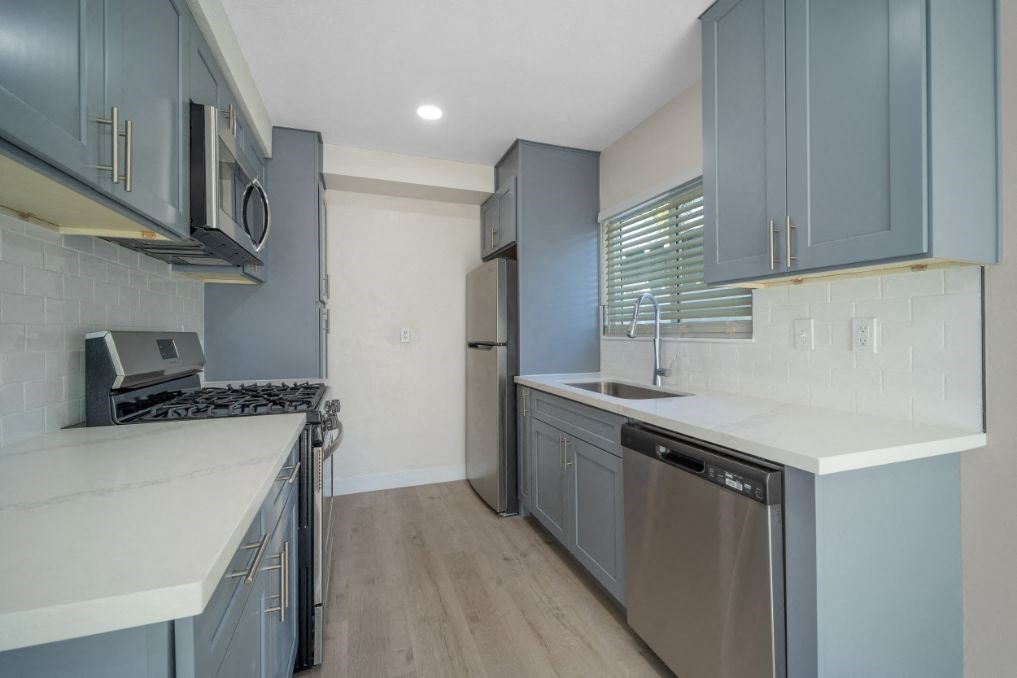 a kitchen with stainless steel appliances and blue cabinets