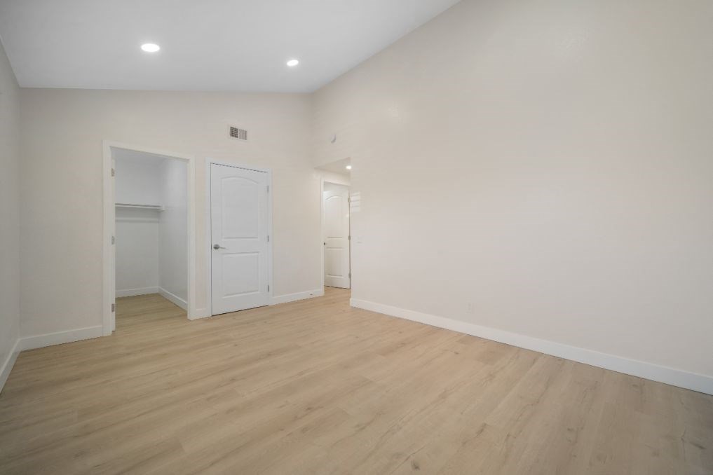 an empty living room with white walls and wood floors