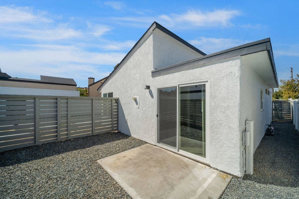 a small white house with a patio and a fence