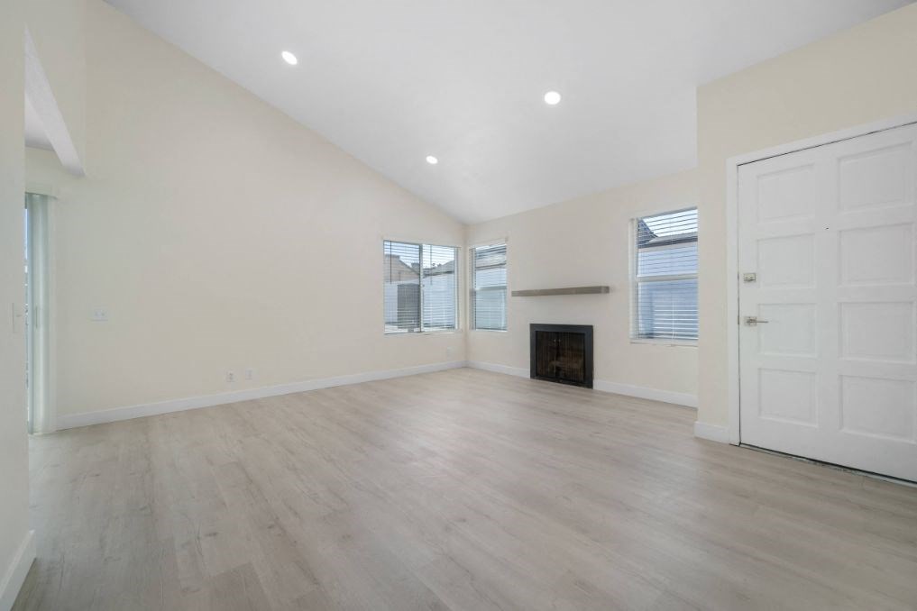 an empty living room with a fireplace and a door
