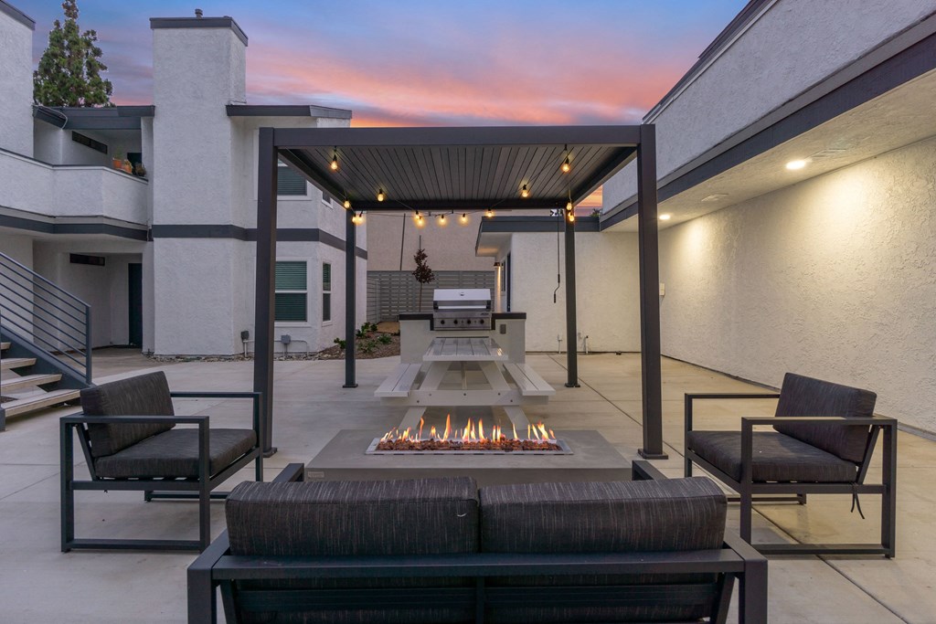 the outdoor patio has a fire pit and seating around it