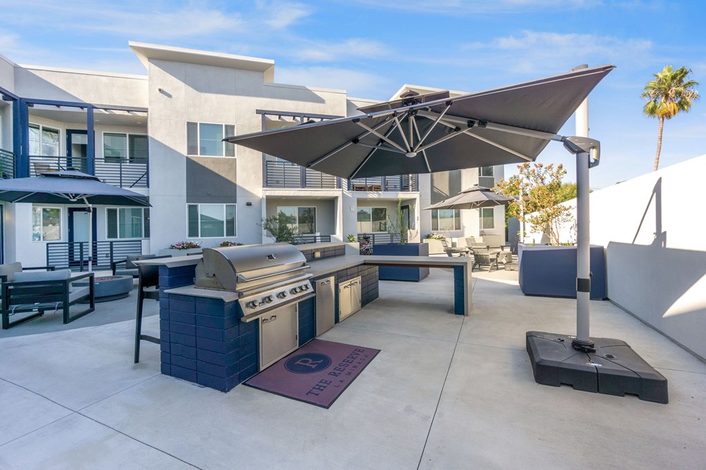 A modern outdoor kitchen area with a grill and seating area. at The Reserve La Mirada, La Mirada, 90638
