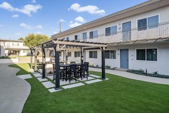 a patio with a table and chairs in front of a building
