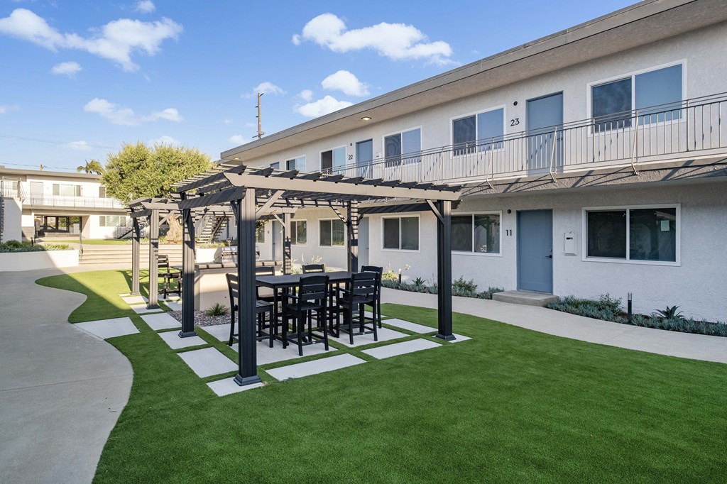 a patio with a table and chairs in front of a building at Arlington Square Apartment , Torrance, California