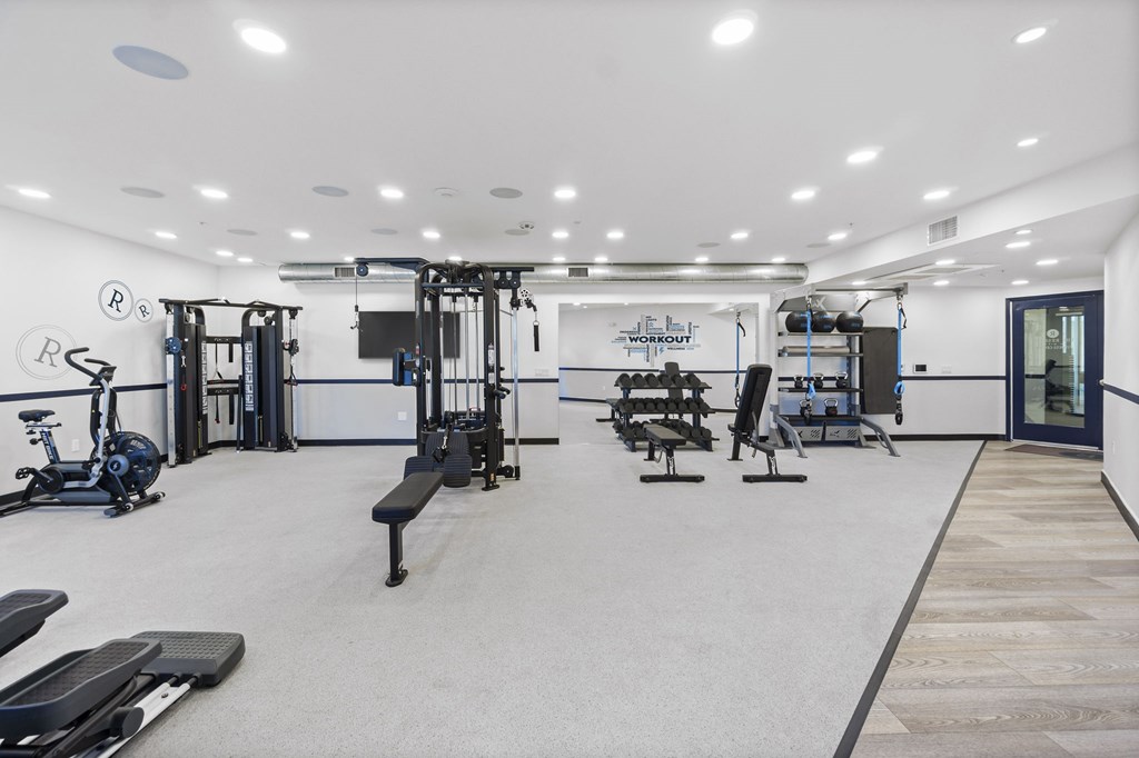 A gym with a variety of equipment including treadmills, weights, and exercise machines.at The Reserve La Mirada, La Mirada, California