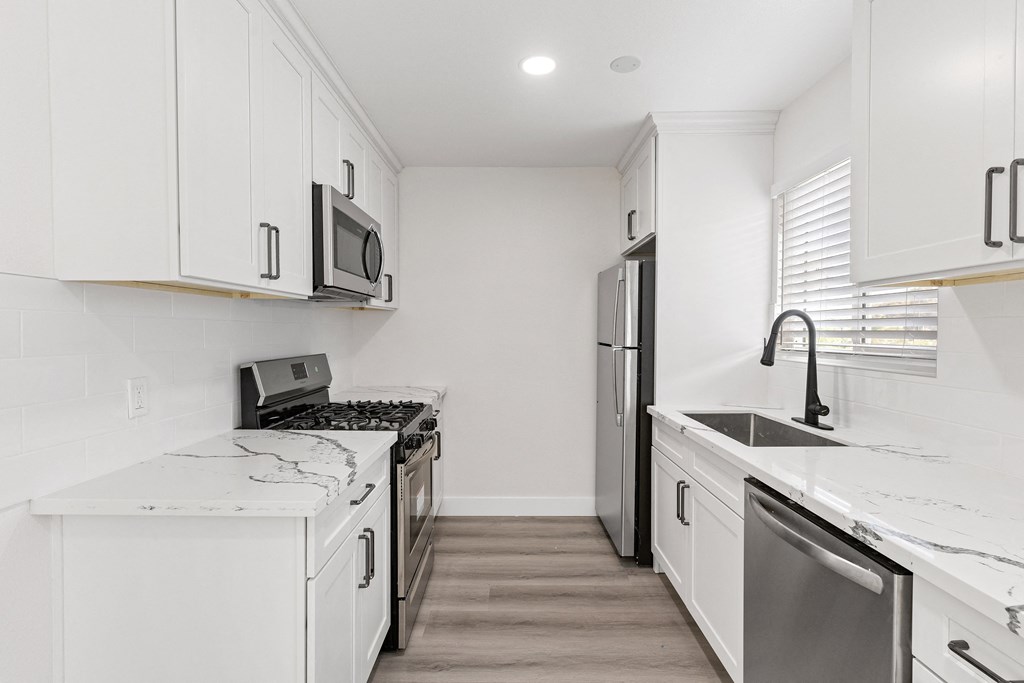 a kitchen with white cabinets and stainless steel appliances at Seaview Terrace Apartment Homes, San Clemente, CA
