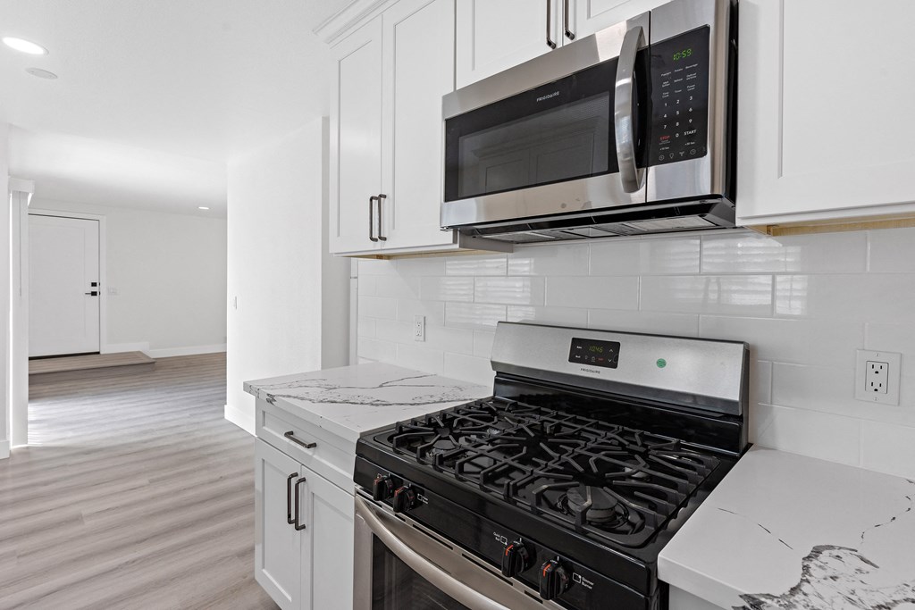 a kitchen with white cabinets and stainless steel appliances at Seaview Terrace Apartment Homes, San Clemente, California