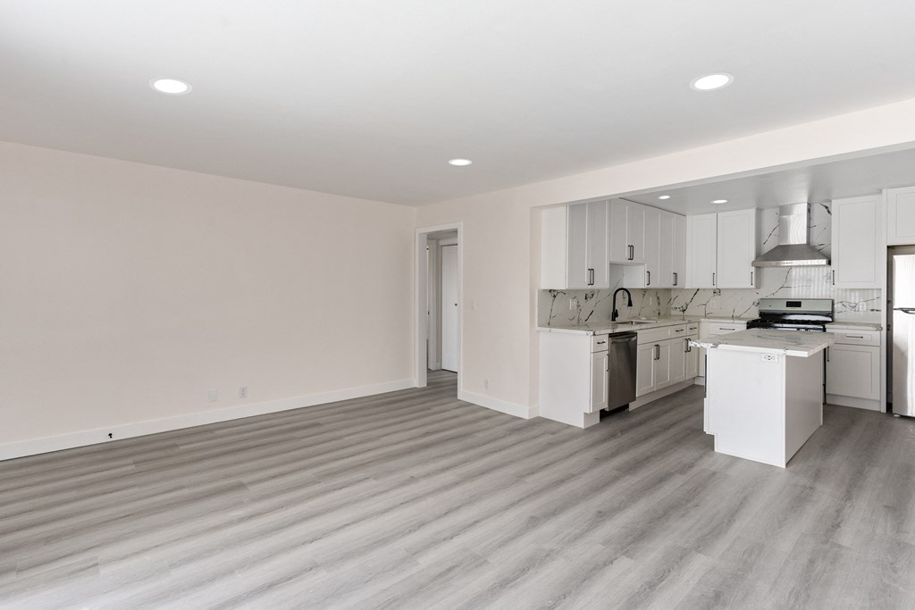 a bedroom with a medium sized bed and a kitchen with a stove and a sink at Seaview Terrace Apartment Homes, San Clemente, 92672