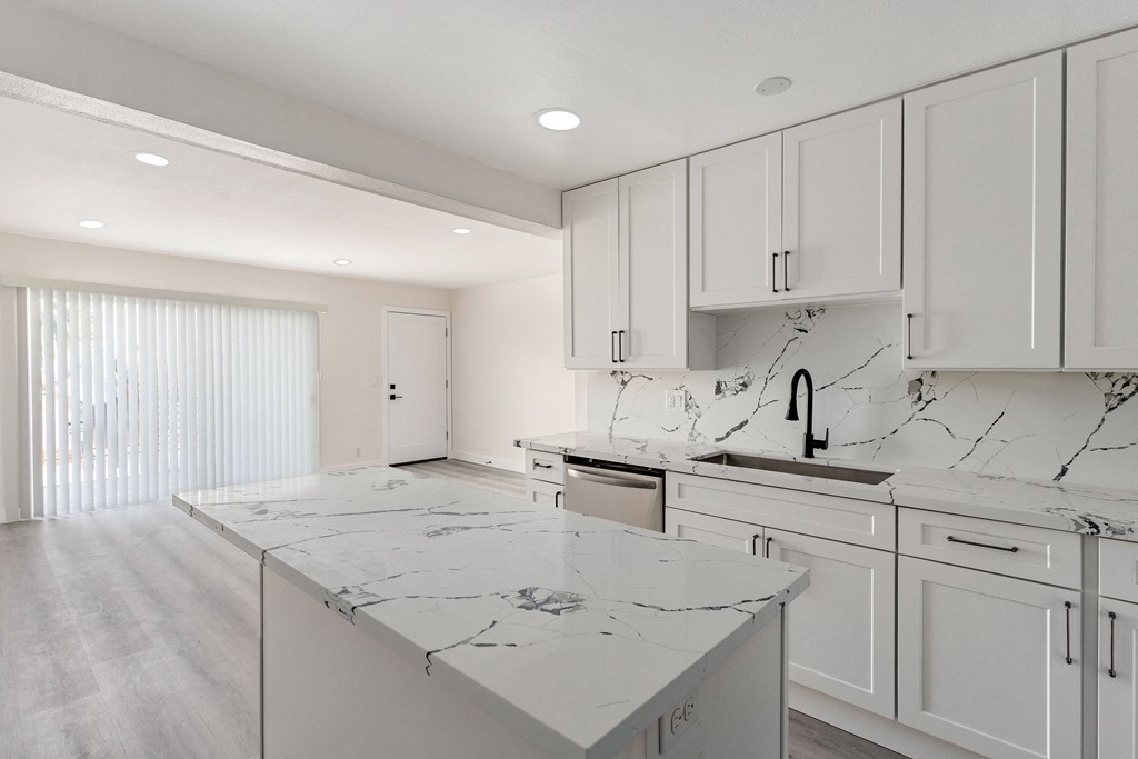 a kitchen with white cabinets and white marble countertops at Seaview Terrace Apartment Homes, San Clemente, California