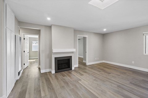 a living room with a fireplace and wooden floors