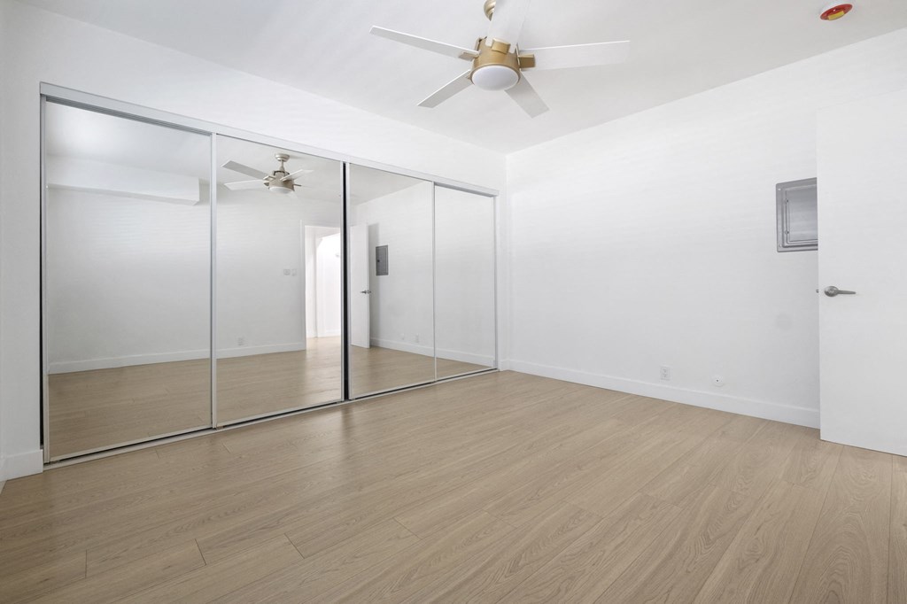 A room with a ceiling fan and a glass door at Arlington Square Apartment , Torrance, 90501