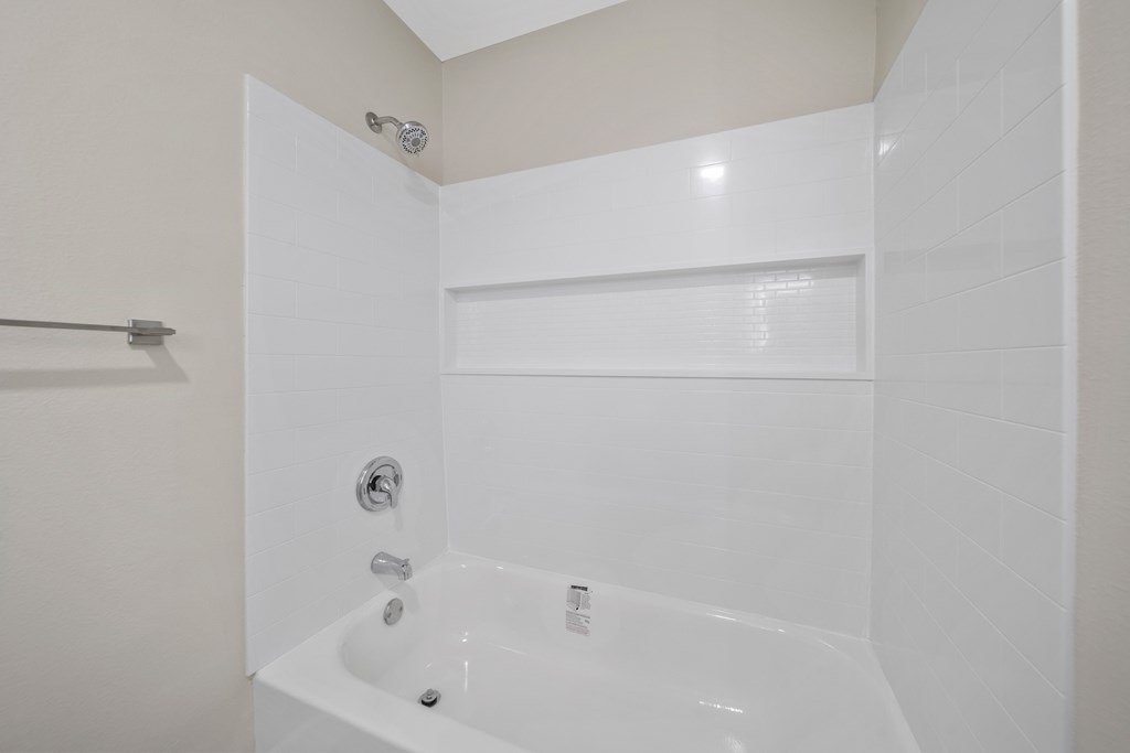 a white bathroom with a tub and a shower