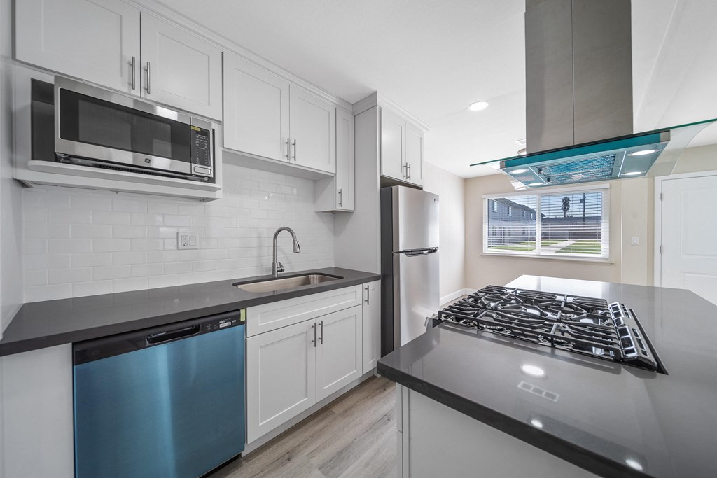a modern kitchen with white cabinets and stainless steel appliances