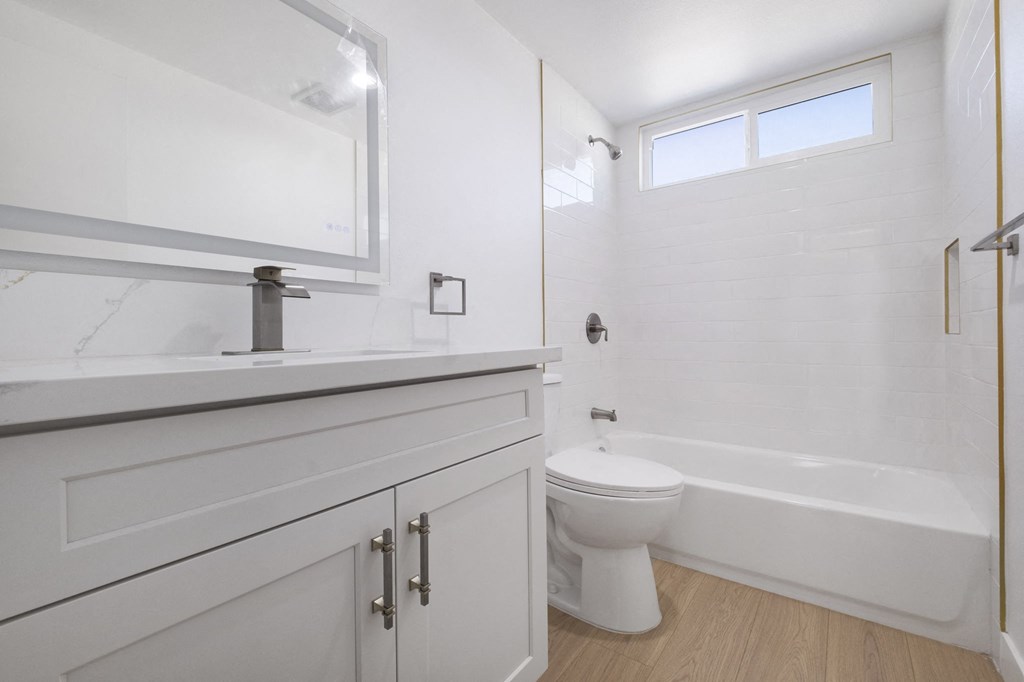 A white bathroom with a toilet, sink, and bathtub at Arlington Square Apartment , Torrance, CA