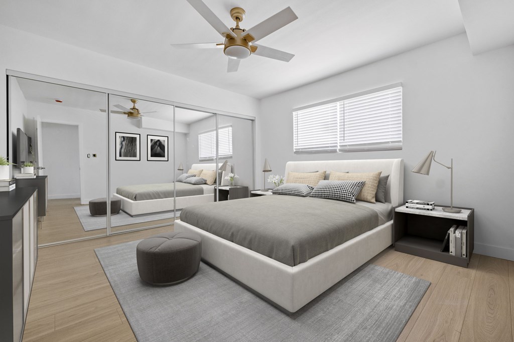 A bedroom with a large bed and a ceiling fan.