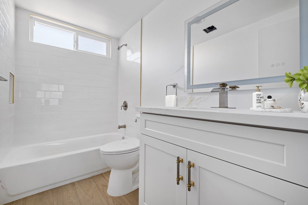 A white bathroom with a toilet, sink, and bathtub.