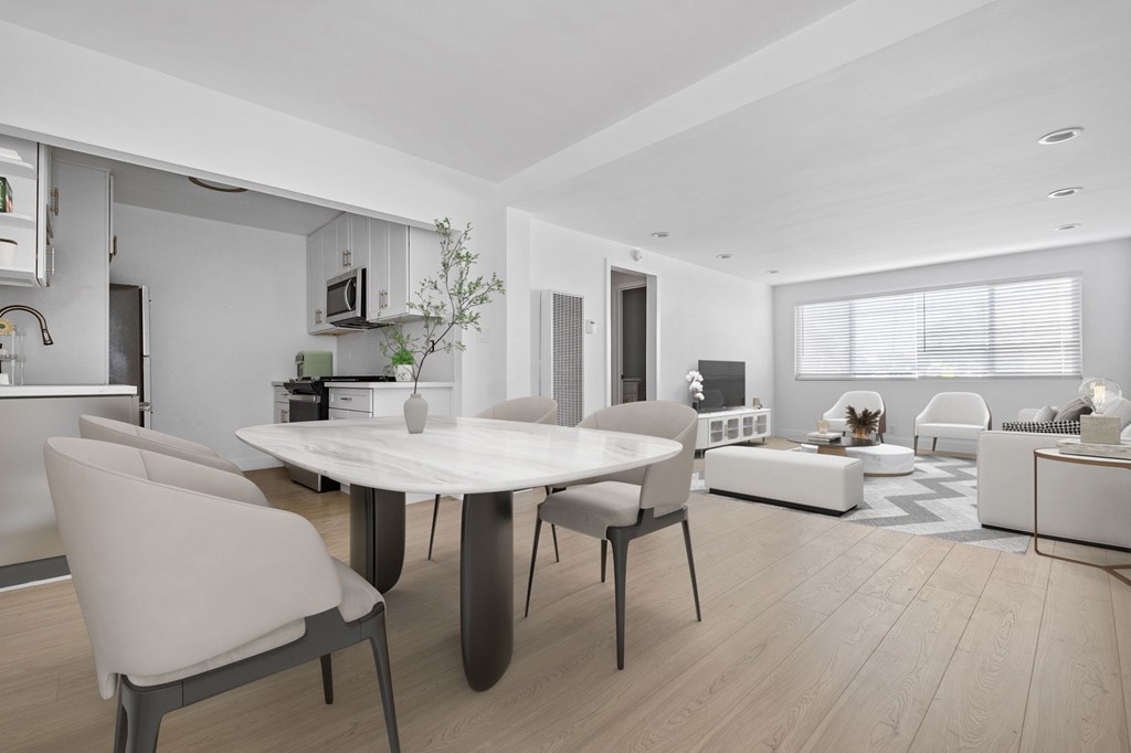 A modern dining room with a white table and chairs.