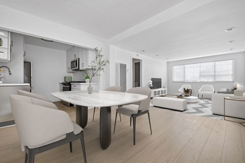 A modern dining room with a white table and chairs.