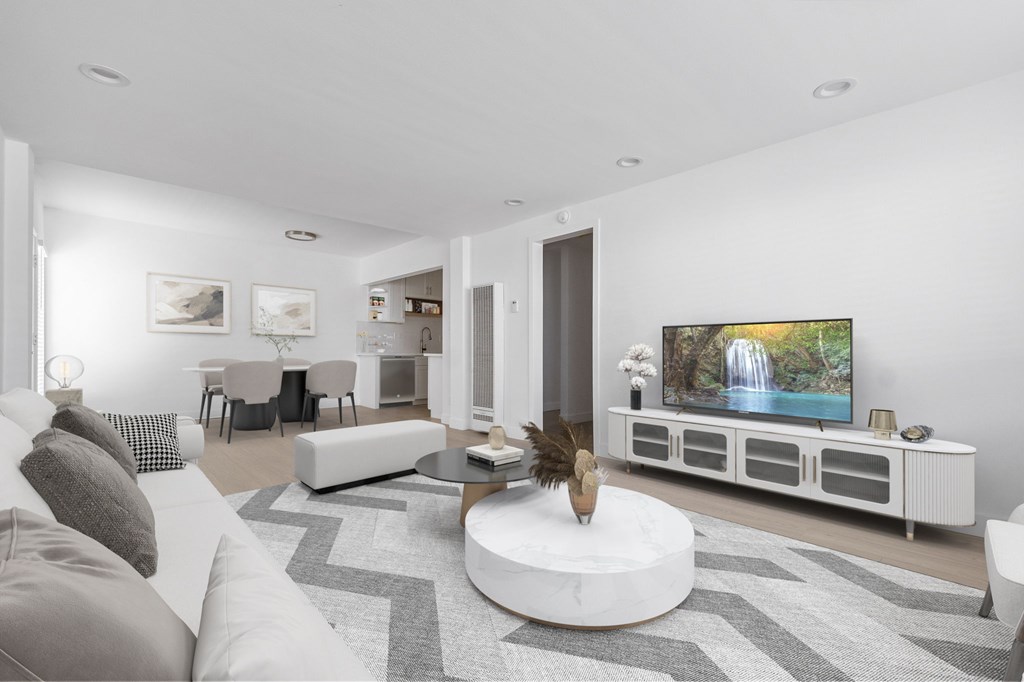 A modern living room with a white couch and a large television.