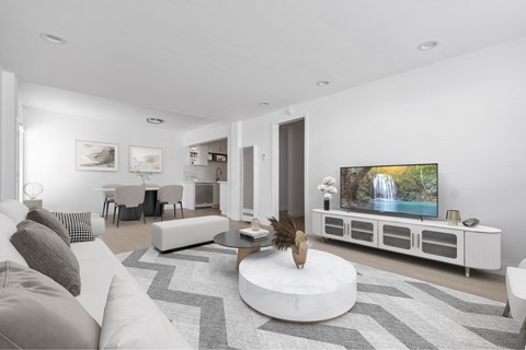 A modern living room with a white couch and a large television.