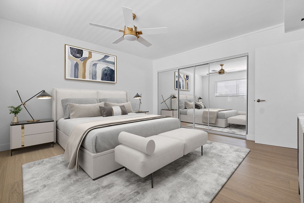 A bedroom with a large bed and a ceiling fan.