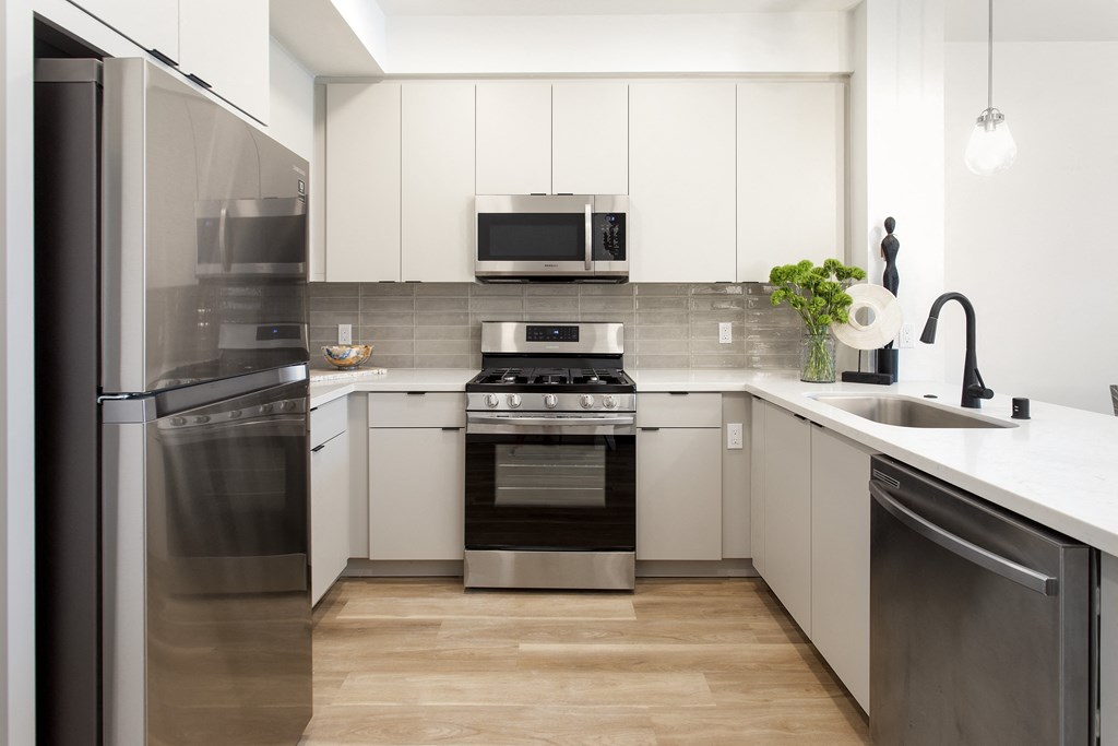 A modern kitchen with stainless steel appliances and white cabinets. at The Reserve La Mirada, La Mirada