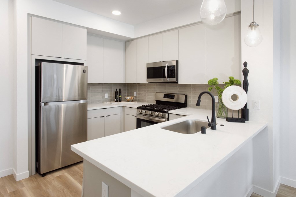 A modern kitchen with a stainless steel refrigerator and a white countertop. at The Reserve La Mirada, La Mirada, California