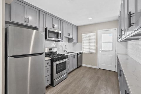 a kitchen with stainless steel appliances and white cabinets