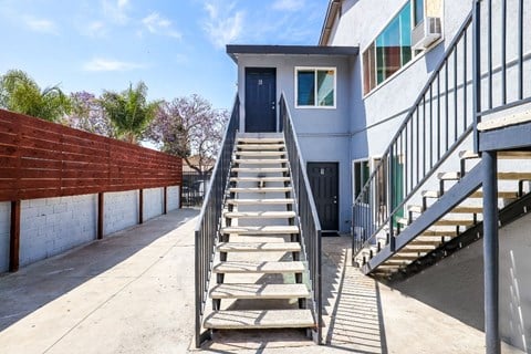 the stairs up to a building with a blue door