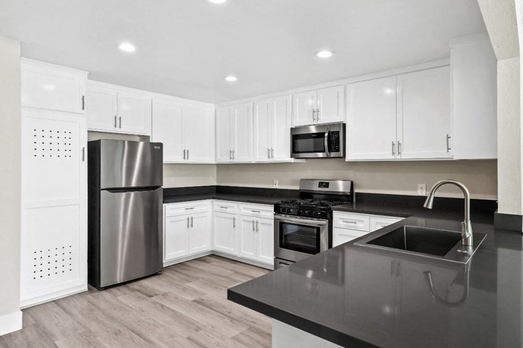 a kitchen with white cabinets and a stainless steel refrigerator