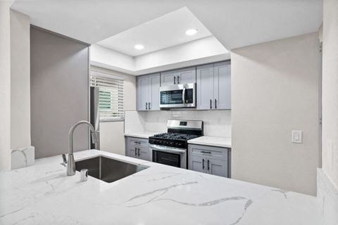 a kitchen with white marble counter tops and a sink