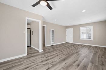 an empty living room with a ceiling fan